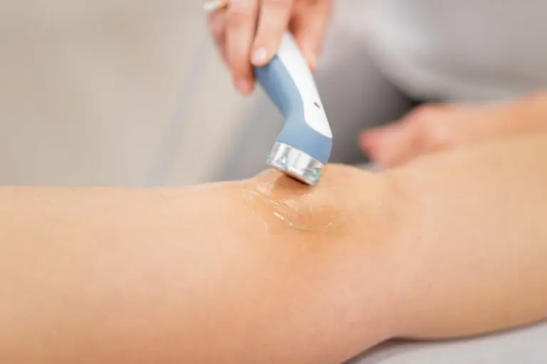 A therapist applying ultrasound therapy to a patient's knee.