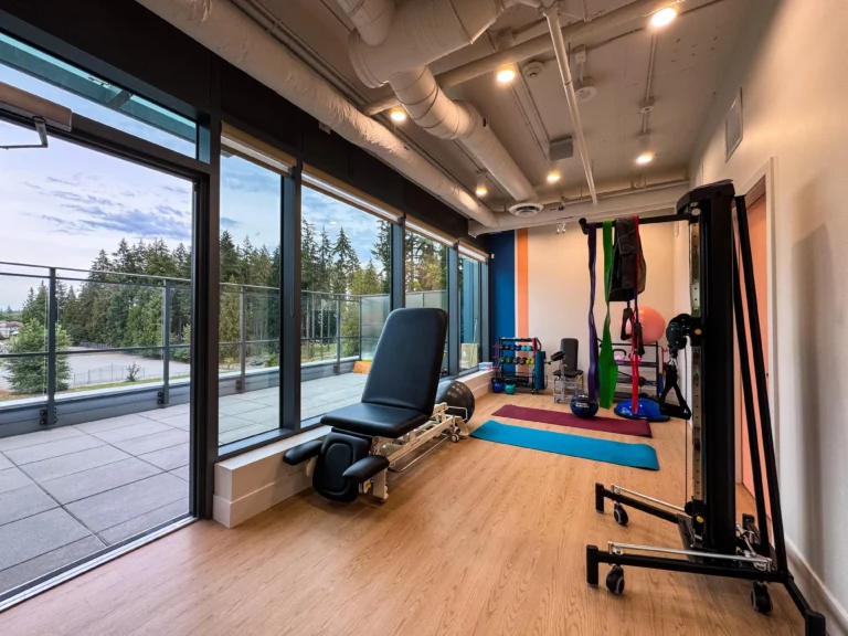 Rehabilitation gym area equipped with various exercise machines and free weights, designed for comprehensive fitness and recovery workouts