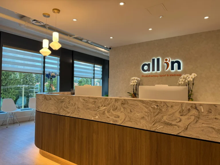 Receptionist area with a modern desk and two computers, leading to a welcoming seating area for visitors, featuring a stylish design and an organized workspace